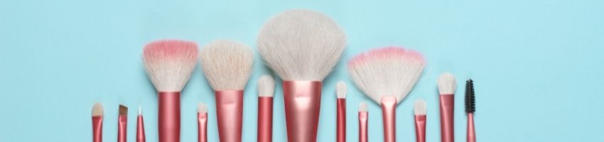 Pink makeup brushes in the skyblue background