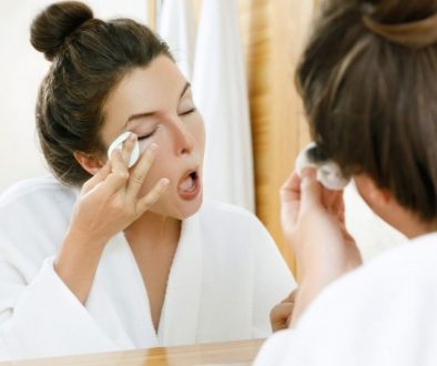 A woman wiping her eye makeup while wondering how to remove eyebrow tint.