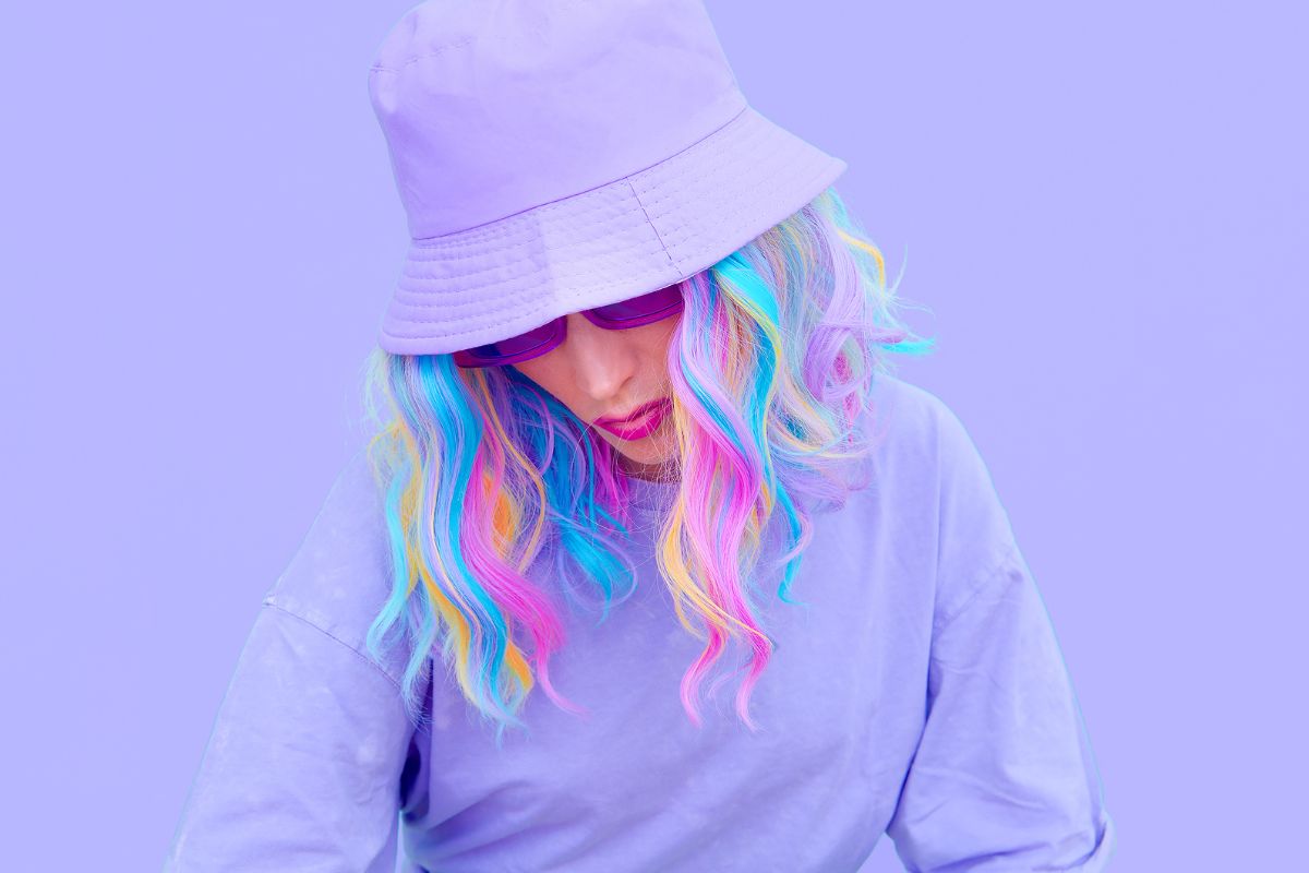 A happy woman is satisfied with her pastel-colored hair that matches her skin tone.