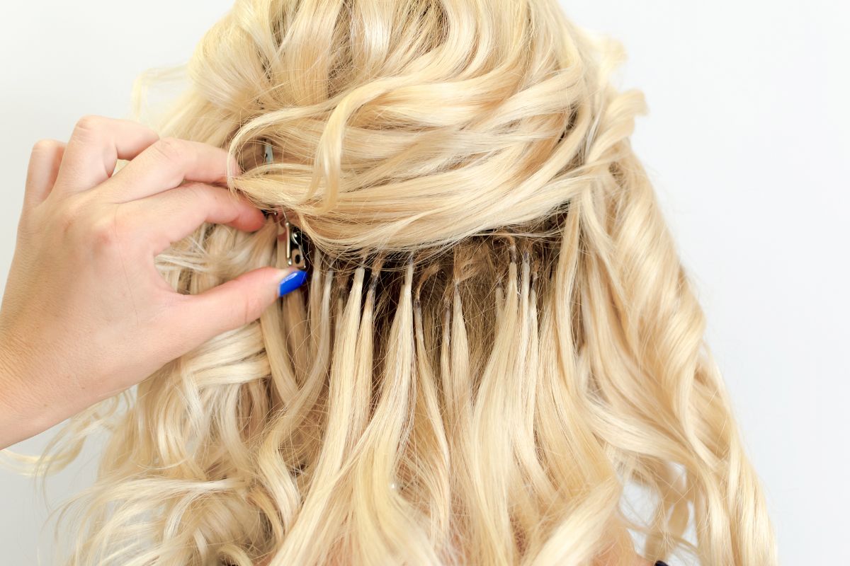 A woman tries to remove the tape from her hair extensions.