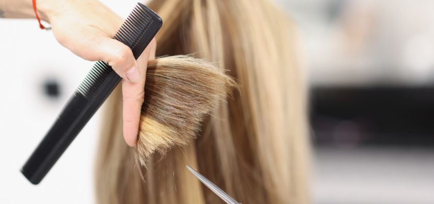 A hairstylist uses one of the most affordable straightening brushes for black women’s hair.