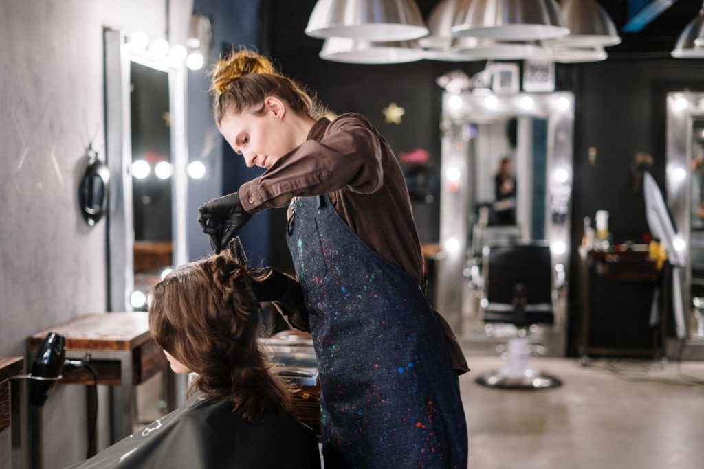 A hairstylist renders complete salon services. They cut, color, shampoo, blow dry, and style tresses.