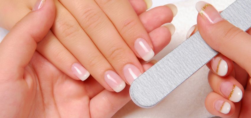 Filing acrylic nails during a manicure, a common step that can explain why do my acrylic nails hurt.