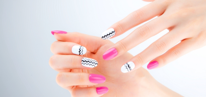 Hands showcasing precise geometric nail art created with a nail printer.