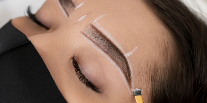 Where should your eyebrows start: professional brow mapping with white guideline lines showing ideal starting point aligned with inner corner of the eye for perfect symmetry